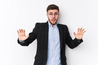 Beyaz arka planda poz veren Kafkasyalı genç iş adamı, yakın bir tehlike nedeniyle şok olan Kafkasyalı genç bir iş adamını tecrit etti.