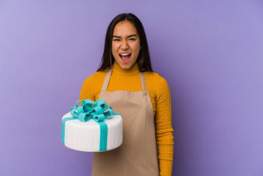 Genç Asyalı bir kadın elinde pasta tutarken izole edilmiş bağırıyor çok sinirli ve agresif.