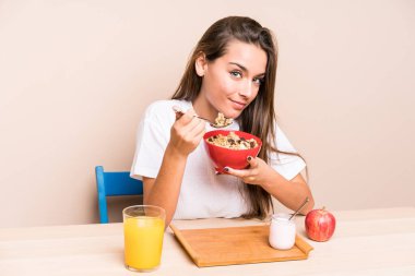 Genç beyaz kadın kahvaltı yapıyor.