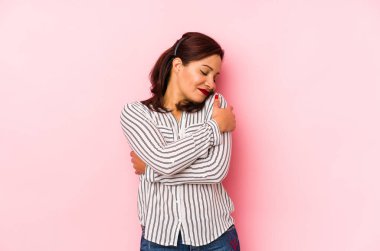 Orta yaşlı Latin bir kadın pembe bir arka planda izole edilmiş, güler yüzlü ve mutlu..