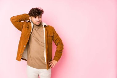 Pembe üzerinde yalnız poz veren genç bir Arap.