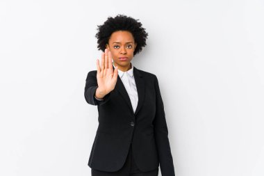 Middle aged african american business  woman against a white background isolated standing with outstretched hand showing stop sign, preventing you.