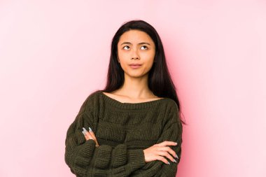 Pembe arka planda izole edilmiş genç Çinli kadın tekrarlanan bir görevden yoruldu..