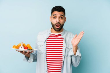 Elinde waffle tutan genç Latin adam şaşırdı ve şok oldu..