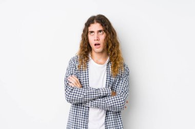 Genç, uzun saçlı bir adam sürekli tekrarlanan bir görevden yorgun düşmüş gibi poz veriyor..