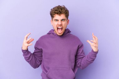 Sarışın, kıvırcık saçlı, beyaz tenli bir adam öfkeyle bağırıyor..