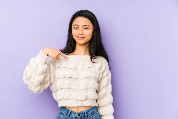 年轻的中国女人被一个紫色背景的人隔离着 手指着衬衫的复制品空间 自豪而自信 — 图库照片