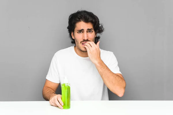 Jongeman Met Een Aloë Vera Fles Bijtende Nagels Nerveus Zeer — Stockfoto