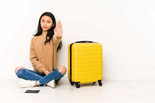 若いです中国人旅行者女性座っています床にスーツケースと独立した立場でアウトストップサインを示す あなたを防ぎます — ストック写真