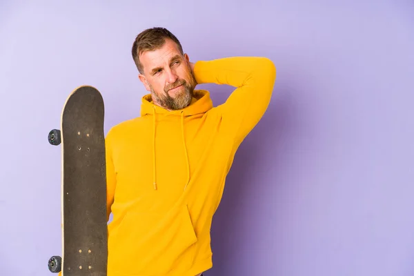 Senior Skater Man Isolated Purple Background Touching Back Head Thinking — Zdjęcie stockowe