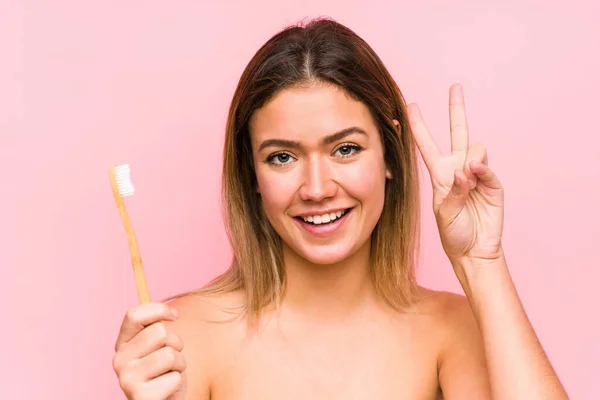 Joven Mujer Caucásica Sosteniendo Cepillo Dientes Aislado Mostrando Signo Victoria — Foto de Stock
