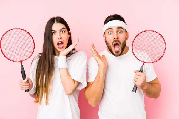 Casal Jovem Jogando Badminton Isolado Surpreso Chocado — Fotografia de Stock