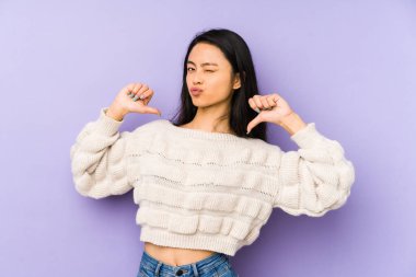 Mor bir arka planda izole edilmiş genç Çinli kadın gururlu ve kendinden emin hissediyor..