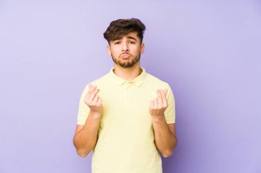 Young arabian man isolated on a purple background showing that she has no money.