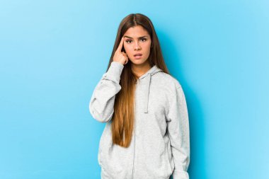 Young sporty woman showing a disappointment gesture with forefinger.