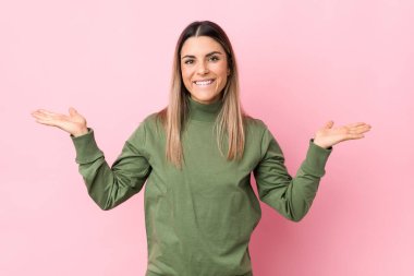 Kafkasyalı genç kadın kollarıyla ölçek yapıyor, mutlu ve kendinden emin..