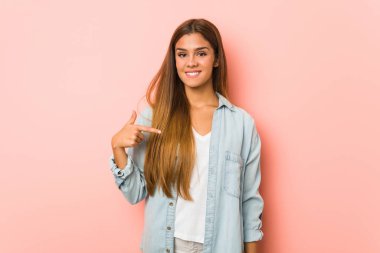 Genç, sıska bir kadın gömleğin fotokopi odasını elle gösteriyor, gururlu ve kendinden emin