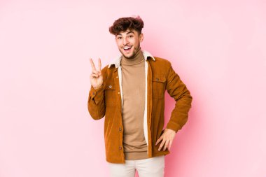 Pembe üzerinde yalnız poz veren genç bir Arap.