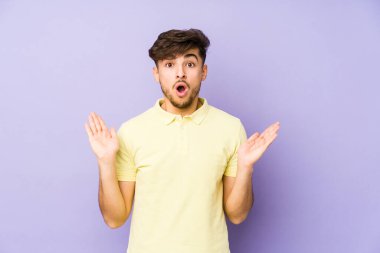 Mor arka planda izole edilmiş genç bir Arap şaşırmış ve şok olmuş..