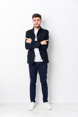 Tam vücut Kafkasyalı genç adam iki seçenek arasında seçim yapmaya çalışıyor..