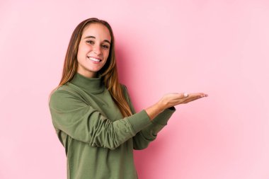 Kafkasyalı genç bir kadın yalnız poz veriyor. Palmiye üzerinde bir kopya alanı tutuyor..