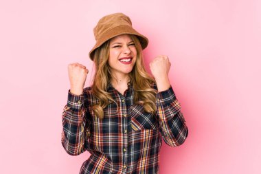 Kafkasyalı şapkalı genç bir kadın yalnız, neşeli ve heyecanlı. Zafer konsepti.