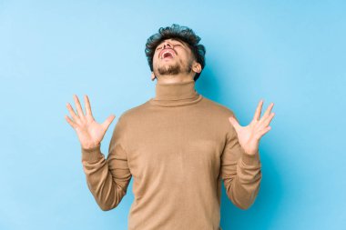 Genç Arap adam gökyüzüne haykırıyor, yukarı bakıyor, hayal kırıklığına uğramış..