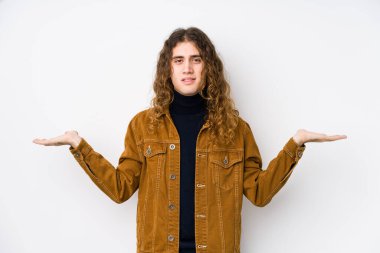 Yalnız poz veren uzun saçlı adam kollarıyla ölçek yapar, mutlu ve kendinden emin hisseder..