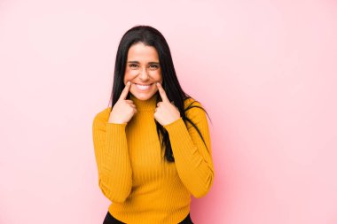 Pembe arka planda izole edilmiş beyaz bir kadın iki seçenek arasında şüphe duyuyor..