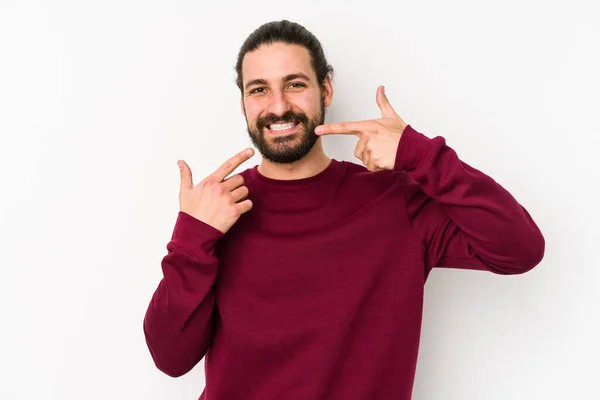 Joven Hombre Pelo Largo Aislado Sobre Fondo Blanco Sonríe Señalando — Foto de Stock