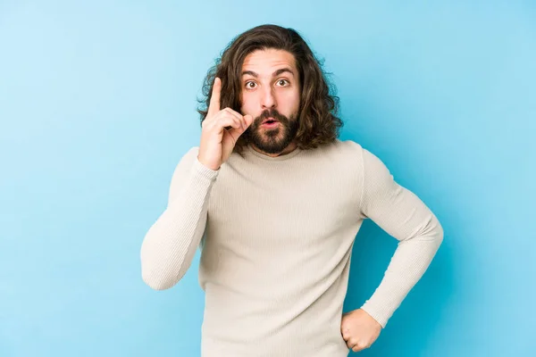 Jonge Lange Haar Man Geïsoleerd Een Blauwe Achtergrond Met Een — Stockfoto