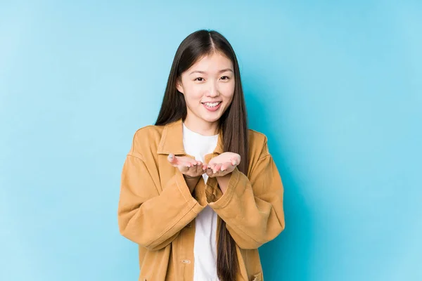 Jovem Chinesa Posando Fundo Azul Isolado Segurando Algo Com Palmas — Fotografia de Stock