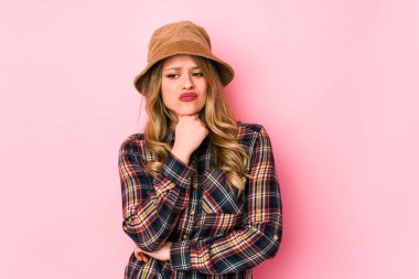 Şapka takan genç beyaz kadın virüs ya da enfeksiyon yüzünden boğazında ağrı hissediyor..