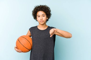 Basketbol oynayan çocuk mavi arka planda izole edilmiş, hoşlanmadığı bir jest gösteriyor, kabul etmiyor. Anlaşmazlık konsepti.