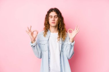 Uzun saçlı adam izole edilmiş poz veriyor. Sıkı çalışma gününden sonra rahatlıyor. Yoga yapıyor..