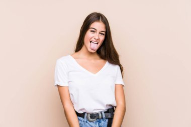 Kafkasyalı genç bir kadın yalnız poz veriyor. Komik ve dost canlısı bir dil uzatıyor..