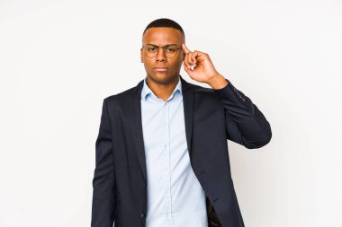 Genç iş adamı, beyaz arka planda izole edilmiş, parmağıyla tapınağı işaret eden, düşünen, bir göreve odaklanmış..