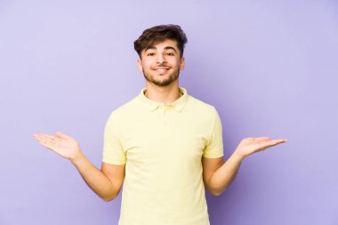 Mor arka planda izole edilmiş genç bir Arap hoş bir yüz ifadesi sergiliyor..