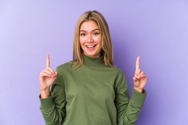 Sarışın, beyaz tenli bir kadın iki ön parmağı da boş bir alan gösteriyor..