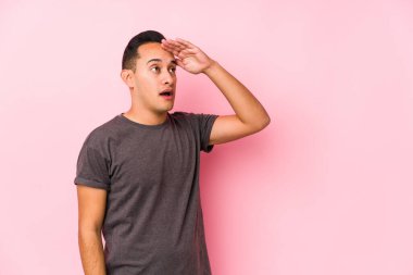 Pembe arka planda poz veren seni gidi Latin adam..