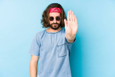 Genç, uzun saçlı, festival hipster 'ı giyen adam izole görünüyor. Elini uzatmış, dur işareti gösteriyor ve seni engelliyor..