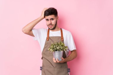 Kafkasyalı genç bahçıvan elinde bir bitki tutuyor. Şok geçiriyordu. Önemli bir toplantıyı hatırladı..