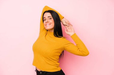 Pembe arka planda izole edilmiş genç beyaz kadın kollarını uzatıyordu, rahat bir pozisyondaydı..