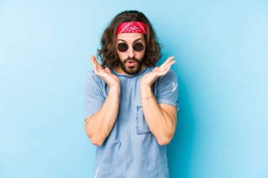 Genç, uzun saçlı, festival elbisesi giyen hippi görünüşlü, şaşırmış ve şaşırmış görünüyor..