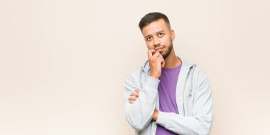 Güney Asyalı genç adam rahatlamış fotokopi odasına bakan bir şey düşünüyor..
