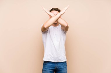 Kafkasyalı genç adam yalnız poz veriyor iki kolu çapraz tutuyor, inkar kavramı.