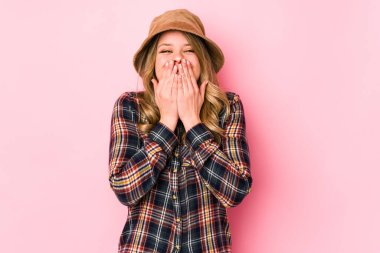 Kafkasyalı şapkalı genç bir kadın bir şeye gülüyor, elleri ağızda..