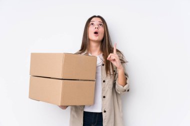 Yeni bir eve taşınan beyaz bir kadın ağzı açık bir şekilde üst tarafı işaret ediyor..