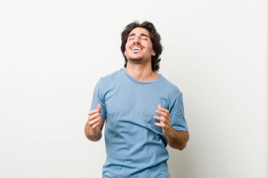 Beyaz arka planda neşeli bir gülüşe karşı genç ve yakışıklı bir adam. Mutluluk kavramı.