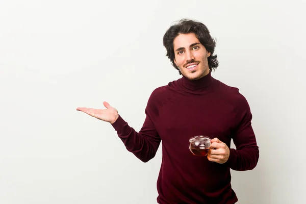 Joven Sosteniendo Una Taza Mostrando Espacio Copia Una Palma Sosteniendo — Foto de Stock